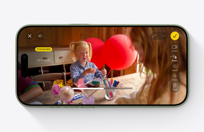 Pohľad spredu na iPhone 17, na ktorom vidno použitie funkcie mix audia pri upravovaní videa s dieťaťom, ktoré sa hrá s balónmi